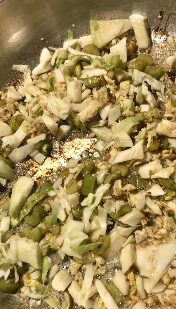 Add cabbage to a skillet with frying celery and eggs.