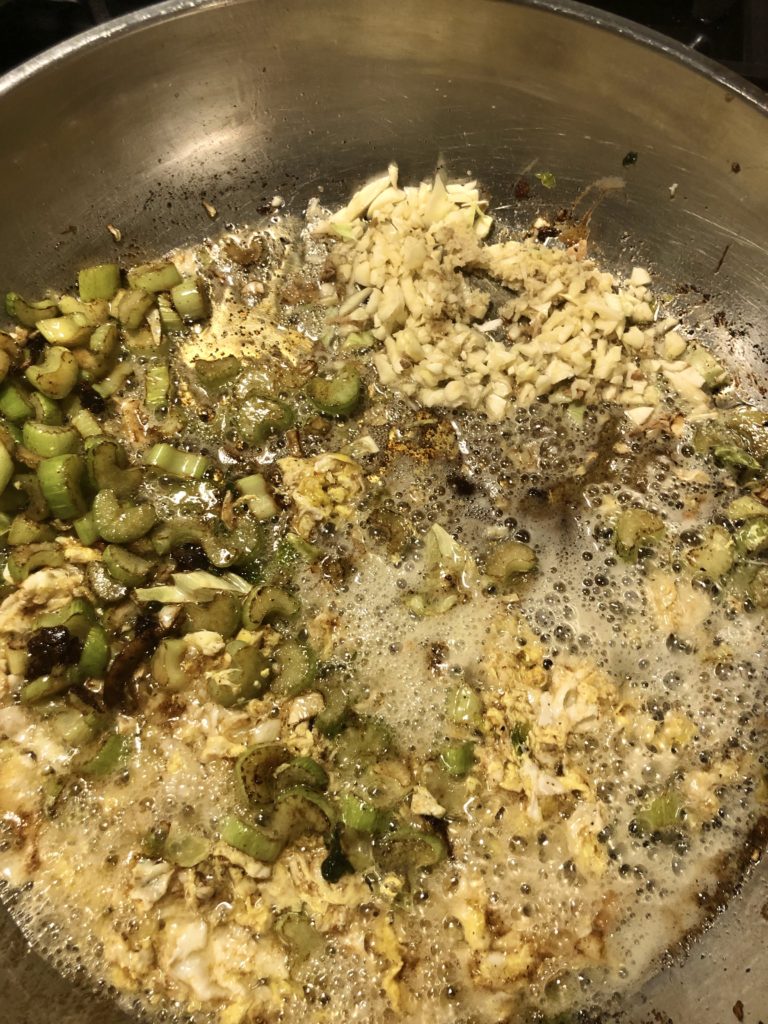 Celery, garlic and ginger frying in a large skillet.