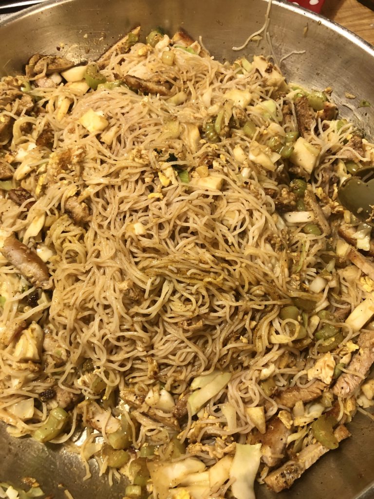 Singapore noodles frying in a pan.