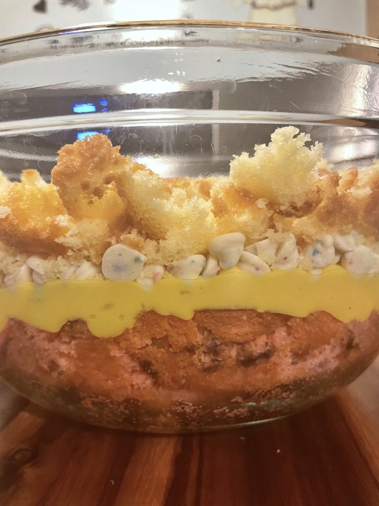 Trifle dish with layers of strawberry cake, vanilla pudding, Funfetti morsels and pound cake.