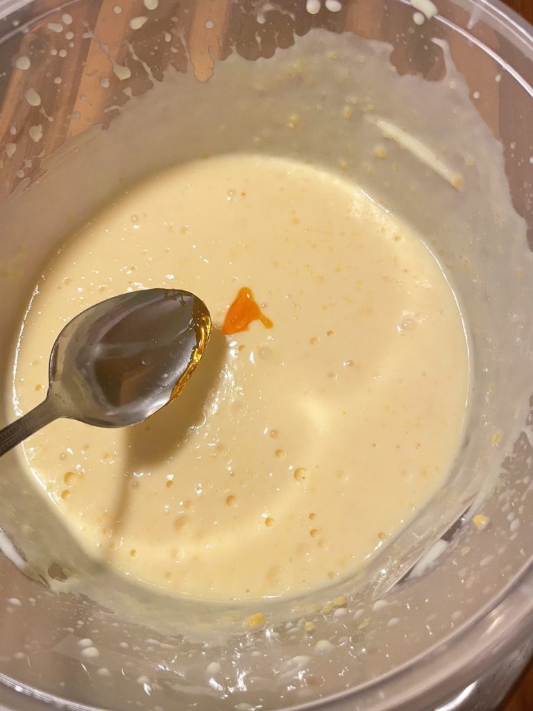 Yellow gel food color being added to instant vanilla pudding.